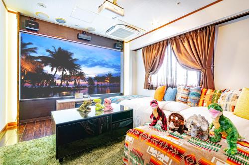 a living room with a large painting of a beach at Hotel Balian Resort Tomei Kawasaki I.C. in Kawasaki