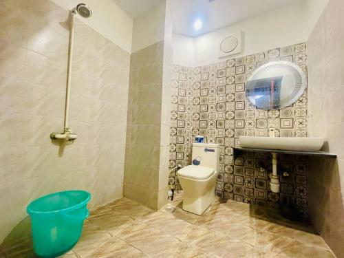 a bathroom with a toilet and a sink and a mirror at Travel Inn clifton in Karachi