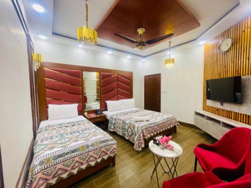 a hotel room with two beds and a tv at Travel Inn clifton in Karachi