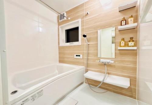 a bathroom with a tub and a toilet and a sink at Lagom Hakuba in Hakuba