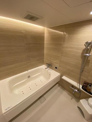 a bathroom with a bath tub and a toilet at hotelzekumochimune in Shizuoka