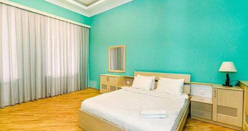 a bedroom with a bed and a blue wall at VIP Apartment in Nizami street Downtown in Baku