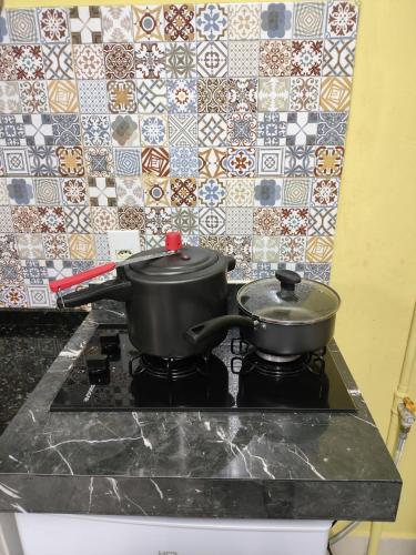 two pots on top of a stove in a kitchen at Pousada Confort in São Paulo