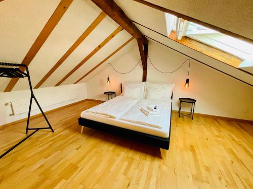 a bedroom with a bed and a tripod in a attic at -TheUrbanist- Sauna Free Parking Fast WiFi in Unterseen