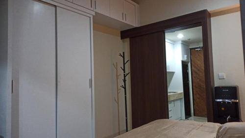 a bedroom with a bed and a large closet at Ruby Apartment #29 in Yogyakarta