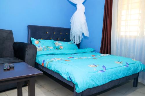 ムトワッパにあるMtwapa Empire Holiday Apartmentsのベッドとソファのある青い寝室