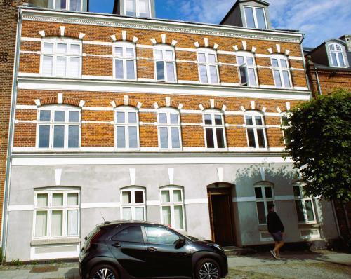 a black car parked in front of a building at Id069 Englandsgade 13, 1th in Esbjerg