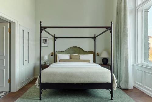 a bedroom with a large bed with a large bed frame at Miiro Palais Rudolf in Vienna