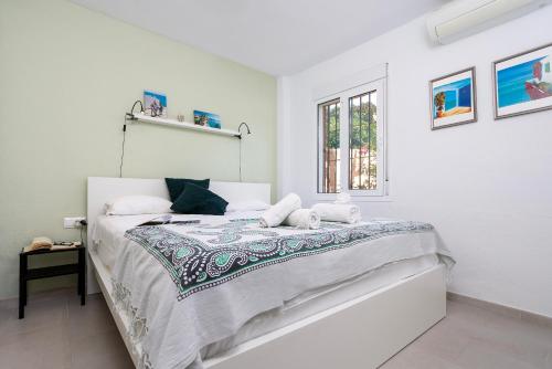 Sunstay Relax Rio Marina Beach Nerja في نيرخا: غرفة نوم بيضاء مع سرير ونافذة