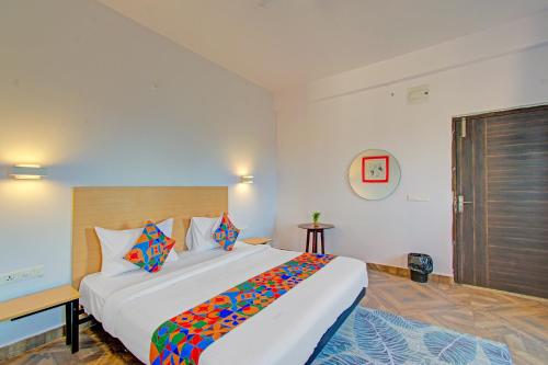 a bedroom with a large white bed with colorful pillows at FabHotel The Vibe - Nr SR Nagar Metro Station in Hyderabad
