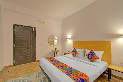 a hotel room with a large bed and a mirror at FabHotel The Vibe - Nr SR Nagar Metro Station in Hyderabad