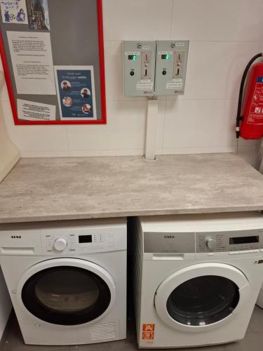 トロムソにあるEazy-Bed Norway's Smallest Hotelの洗濯機2台とカウンター付きのランドリールーム