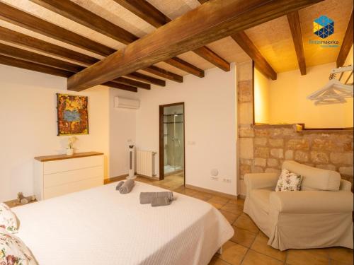 ein Schlafzimmer mit einem Bett und einer Couch in einem Zimmer in der Unterkunft Finca rural S'Art 9 in Ses Salines