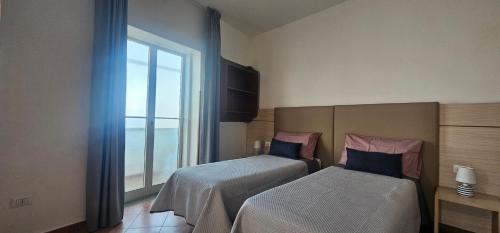 Ένα ή περισσότερα κρεβάτια σε δωμάτιο στο Holiday House Nuvola TROPEA CENTRO WIFI PARKING