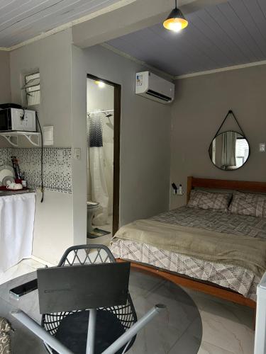 a bedroom with a bed and a mirror and a chair at A melhor localização de Belém do Pará in Belém