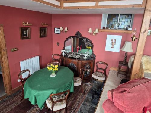 a living room with a table and a mirror at Kilfinichen Church in Kilfinchen