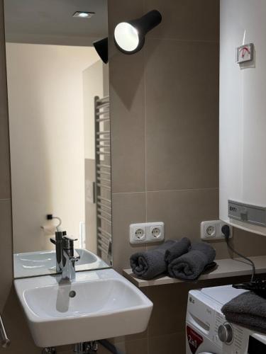 a bathroom with a sink and a mirror at Yellow House Apartments - Top 3 in Steyr
