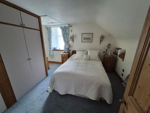 a bedroom with a large white bed and a window at Kilfinichen Church in Kilfinchen