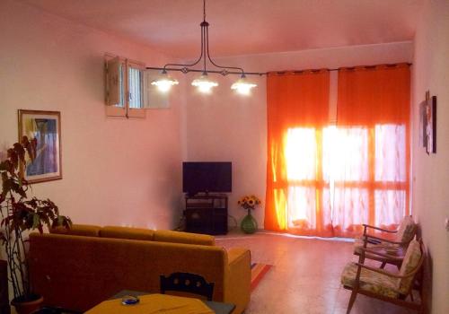 a living room with a couch and a tv at Appartamento La Pinetina in Valderice