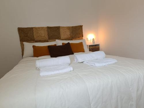 ein großes weißes Bett mit vier Kissen darauf in der Unterkunft El rinconcito de Bruno in Arcos de la Frontera