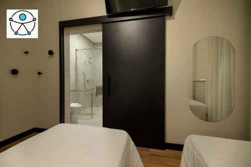 um quarto com uma porta preta e um espelho em Morada Inn Hotel em Franca