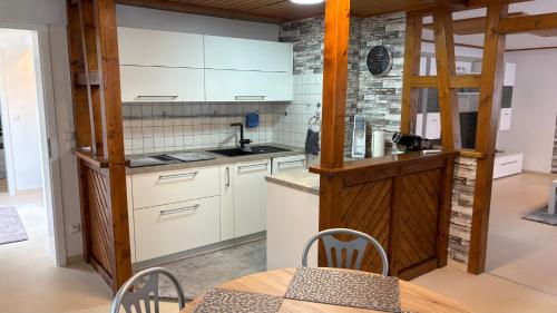 a kitchen with white cabinets and a table at LembergLodge Gosheim in Gosheim