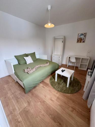 a bedroom with a large green bed and a table at Green 3 - Roubaix Gare in Roubaix