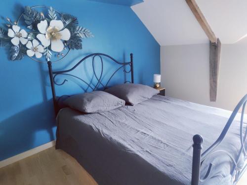 Loscouët-sur-MeuDetached house in a Breton farmhouse的卧室里有一张床，墙壁是蓝色的