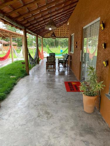 a patio with chairs and a table and a hammock at Casa às margens do Rio Caraíva, área verde in Caraíva