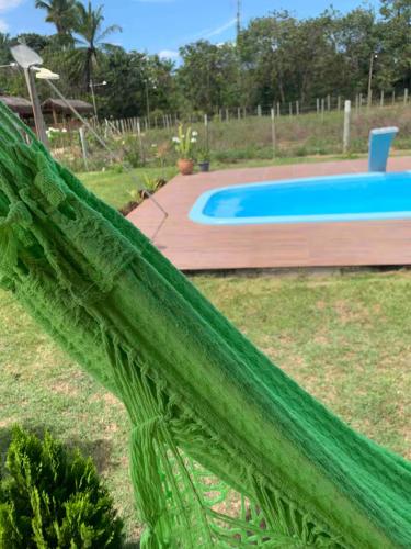 a green net in front of a swimming pool at Casa às margens do Rio Caraíva, área verde in Caraíva