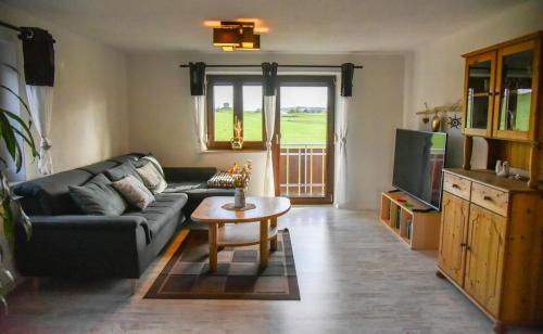 a living room with a couch and a table and a tv at Ferienwohnung Osterberg in Unterthingau