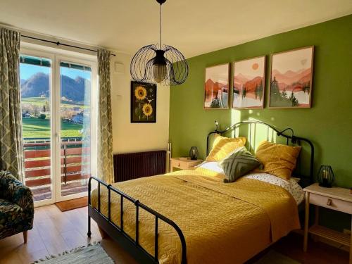 een groene slaapkamer met een bed en een raam bij Mountain Vista Apartment in Bled
