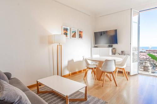 a white living room with a table and a couch at T2 central Beausoleil in Beausoleil
