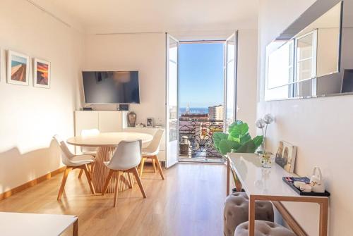 a living room with a table and chairs and a large window at T2 central Beausoleil in Beausoleil