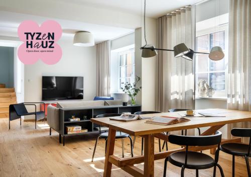 クラクフにあるTyzenhauz Villasのテーブルと椅子とテレビのあるリビングルーム