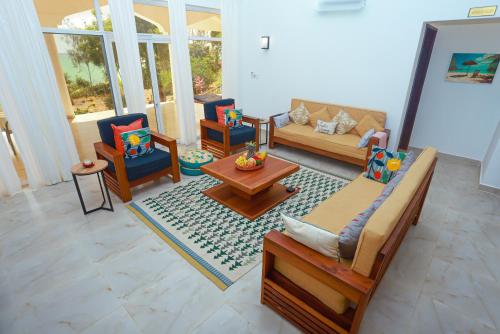 a living room with couches and chairs and a table at Menai Bay Escape in Mkunguni