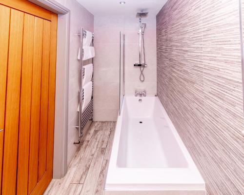 un baño con bañera y lavabo en Wheatsheaf Inn, Bar Hill, en Onneley