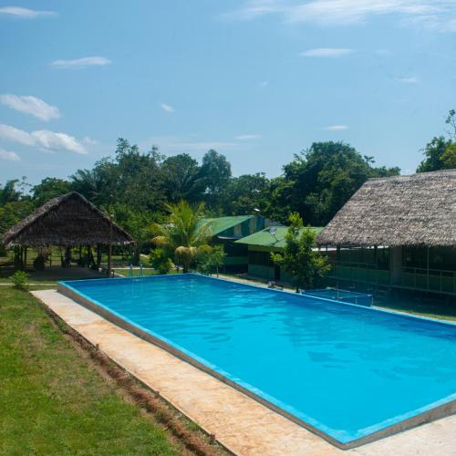 a large blue swimming pool next to a building at Maniti Eco-Lodge in Francisco de Orellana