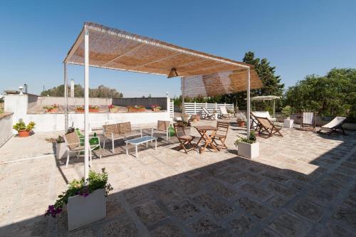 a pavilion with chairs and tables on a patio at Casina Grassi In Salento in Aradeo