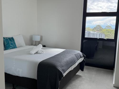 a bedroom with a large bed with a window at Modern 2BR Free parking near Olympic park in Sydney