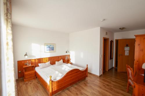 a bedroom with a wooden bed in a room at Brauereigasthof Gut Forsting in Pfaffing