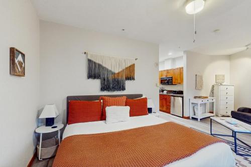 a bedroom with a large bed with orange pillows at Main Street Station #1210 in Breckenridge