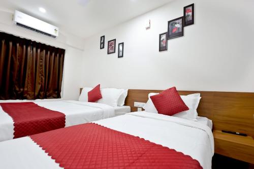 twee bedden in een hotelkamer met rode en witte lakens bij Hotel Arctic Gold in Cochin