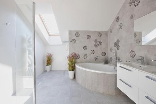 a bathroom with a tub and a sink at Rezort Gothal Apartmány a Penzióny in Donovaly
