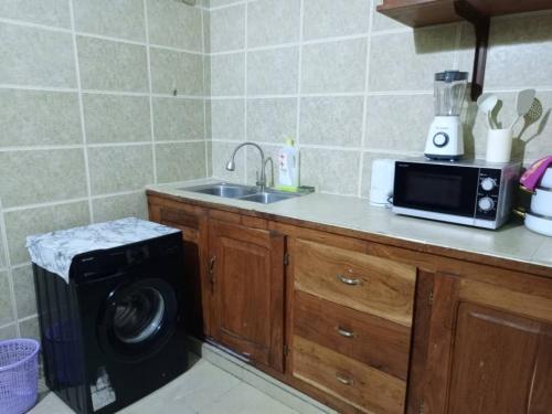 een keuken met een spoelbak en een wasmachine bij Wiston Services in Cotonou