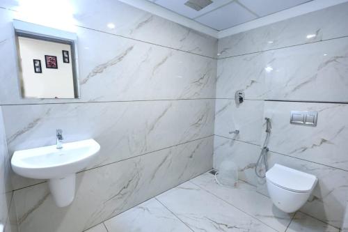 een witte badkamer met een wastafel en een toilet bij Hotel Arctic Gold in Cochin