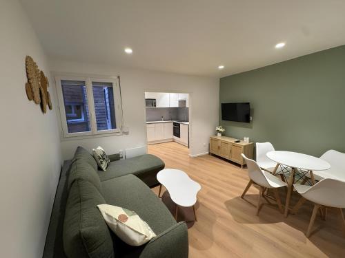 a living room with a couch and a table and chairs at L'Olivier RDC in Abbeville