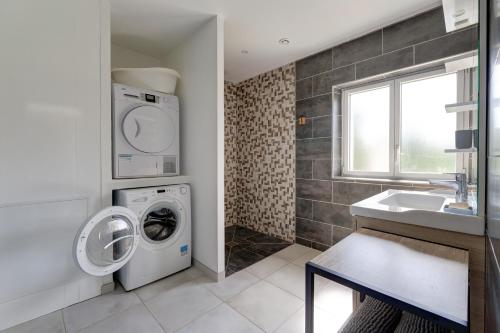 a bathroom with a washing machine and a sink at Le Vert Bocage - Avec Jardin in Rouvroy-sur-Serre