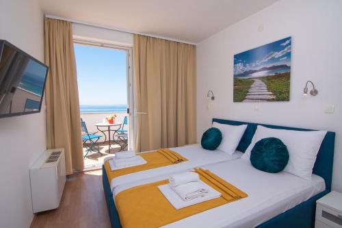 a bedroom with a large bed with a view of the ocean at Villas Royal III in Novalja