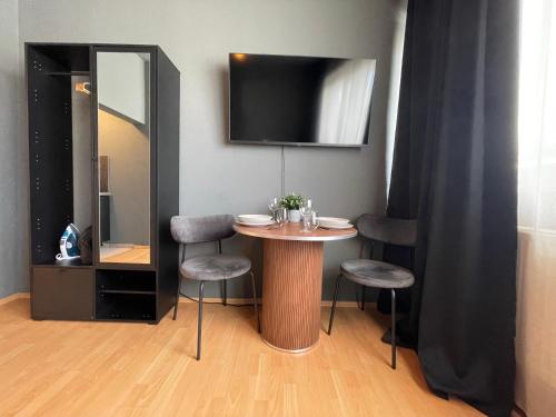 a small table with two chairs and a mirror at Gemütliche Innenstadt Apartments in Stuttgart Stadtmitte in Stuttgart